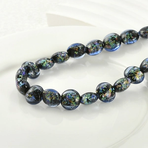 Macro shot of flat round glass beads with colorful foil inserts for DIY jewelry making