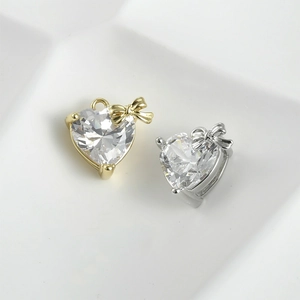 Glistening zircon heart pendant with bow detail in 14k gold and silver finishes