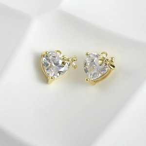 Close-up of sparkling heart zircon pendant with golden bow for DIY jewelry making