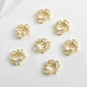 Makroaufnahme von 14k Gold-Schleifenkranz-Anhänger mit Zirkonia-Steinen und Schmetterlingen