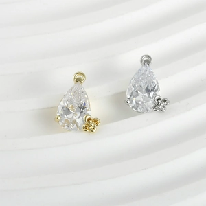 Detailed macro of teardrop zircon pendants in gold and silver settings for DIY jewelry