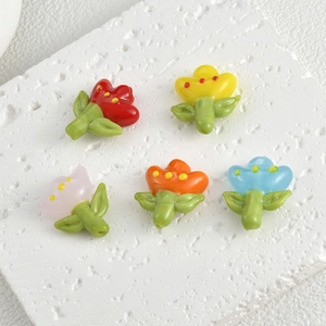 Colorful glass tulip flower beads for DIY jewelry making sets on white stone surface