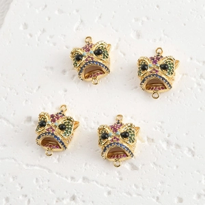 Vista de detalle de cuatro colgantes de león de danza bañados en oro 18k con circonitas