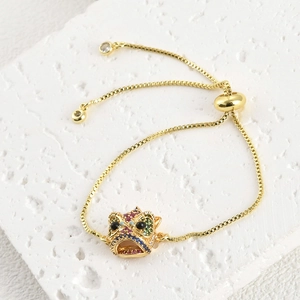 Detalle de pulsera ajustable bañada en oro 18k cabeza de león con circonitas de colores