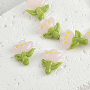 Macro view of handmade glass tulip beads for DIY jewelry making on stone base