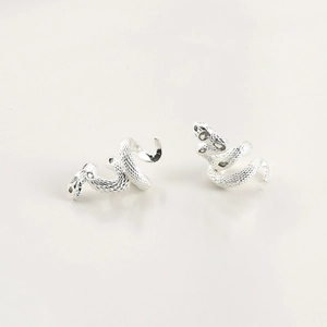 Detailed view of silver snake stud earrings with realistic textured scale patterns