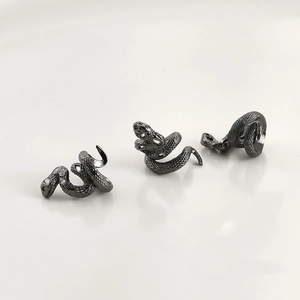 Detail of matte black snake-shaped spacers with realistic scale texture for DIY jewelry