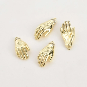 Detailed view of four 14k gold-plated evil eye hand charms with zircon inlay for DIY crafts