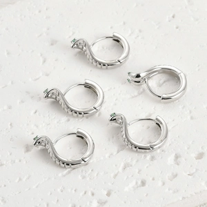 Détail de boucles d'oreilles serpent en argent avec incrustation de zircon vert