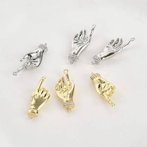 Close-up of 14k gold and silver hand charms with micro-pave wrist details for DIY jewelry