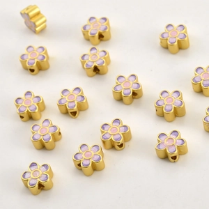 Macro detail of 18k gold floral beads with purple enamel for DIY jewelry making