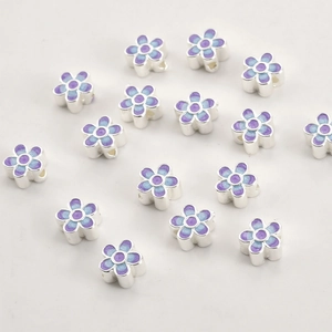 Macro shot of 18k gold plated gradient blue and purple enamel flower beads for DIY crafts
