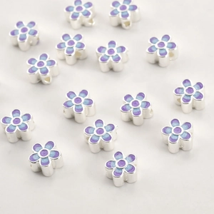 Detailed macro view of 18k gold blue and purple enamel flower beads for DIY jewelry making