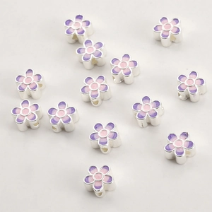 Macro detail of 18k gold gradient purple enamel flower beads for DIY jewelry making