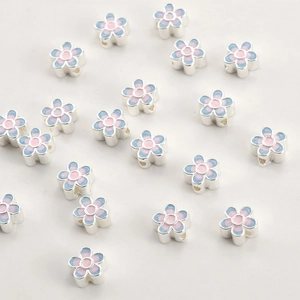 Detailed close-up of 18k gold gradient blue enamel flower spacer beads for DIY jewelry