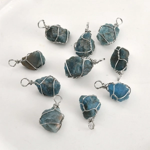 Flat lay of handmade silver wire wrapped raw blue apatite crystal gemstone pendants