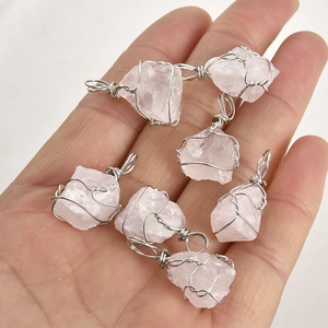 Detailed view of six raw pink crystal pendants with handmade silver wire wrapping