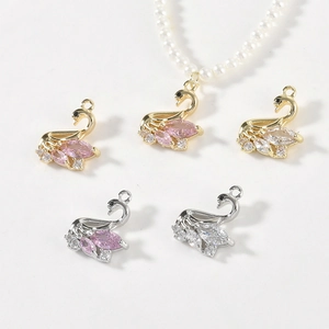 Detail of 14k gold-filled swan pendants with pink cubic zirconia for jewelry making