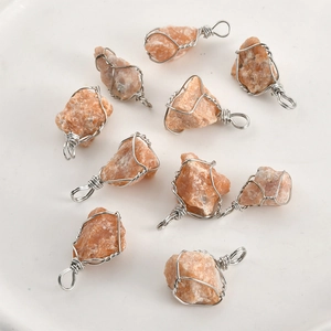 Detailed set of 10 handcrafted raw orange crystal pendants wrapped in silver wire