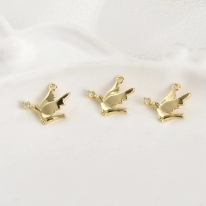 Détail macro de trois pendentifs oiseaux plaqués or 14k avec accents en zircone cubique