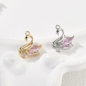 Detail of 14k gold-filled swan pendants with pink zircon stones for DIY jewelry making
