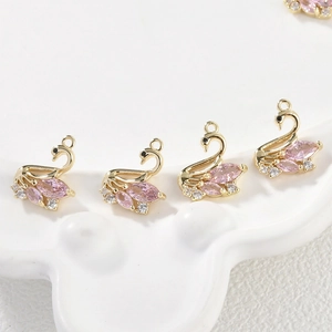 Detailed view of 14k gold plated swan charms with pink zircons for DIY jewelry making