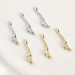 Detailed view of 14k gold and silver plated twisted bar pendants with zircon inlays