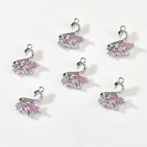 Macro shot of 14k gold plated swan pendants featuring pink marquise and white zirconia
