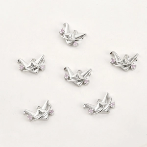 Detailed view of six 14k gold-filled origami crane charms with pink zirconia stones