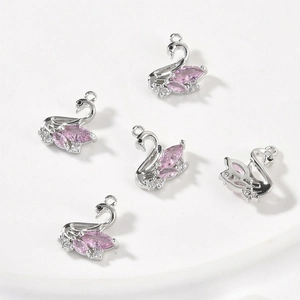 Macro detail of swan pendants with pink marquise crystals and pavé zircon stones