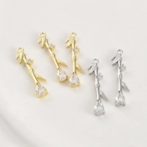 Detail of 14k gold plated bamboo pendant with teardrop zircon and leaf accents