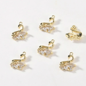 Close-up of 14k gold-filled swan charms with sparkling white zircon for DIY jewelry