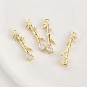 Macro detail of 14k gold plated bamboo pendants with teardrop zircon and pavé accents