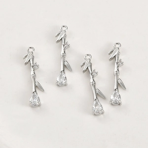 Detailed view of silver bamboo-style pendants with zircons for jewelry making