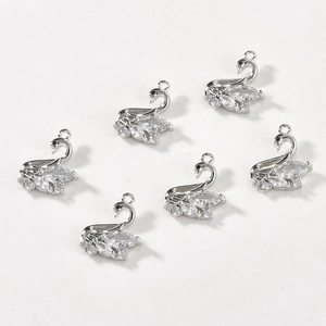 Close-up of 14k gold-filled swan pendants with sparkling cubic zirconia for DIY jewelry