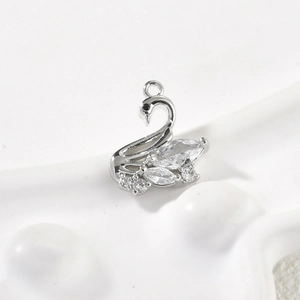 Macro shot of 14k gold-filled swan charm with pink cubic zirconia for DIY jewelry