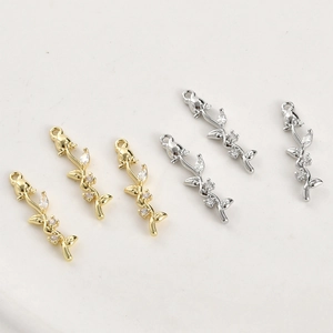 Macro shot of 14k gold-plated rose and bamboo pendants with micro-inlaid zircon details