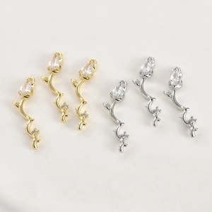 Detailed macro view of 14k gold and silver plated rose twig pendants with zircon stones