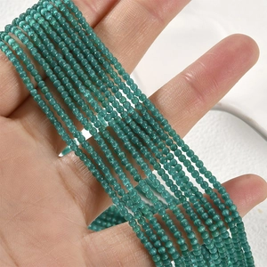 Nahaufnahme kleiner 2mm grüner Katzenaugen-Perlen für DIY-Schmuck mit feinen Facetten