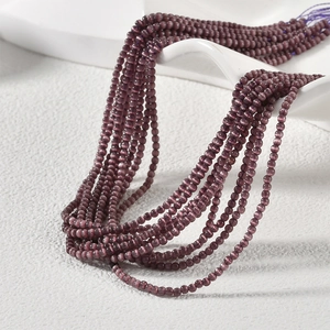 Makro-Detail von 2 mm lila Katzenaugen-Glasperlen für DIY-Schmuck und Perlenstickerei