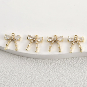 Macro detail of 14k gold plated bow pendants with sparkling cubic zirconia for DIY jewelry