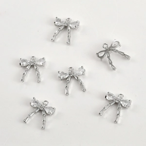 Macro view of 14k gold-plated bow pendants with cubic zirconia for DIY jewelry making