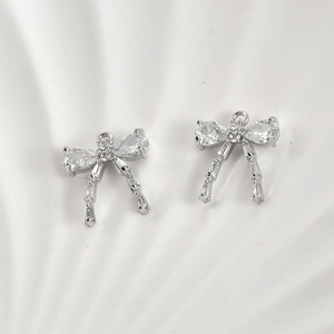 Macro detail of silver bow pendant with cubic zirconia for jewelry making and earrings