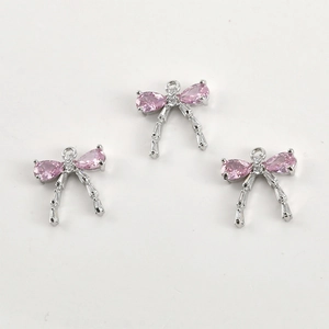 Detail of 14k gold plated bow pendant with pink stones and zircon for jewelry making