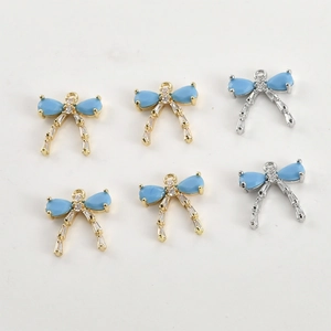 Macro detail of long bow charms with blue stones and cubic zirconia for DIY jewelry