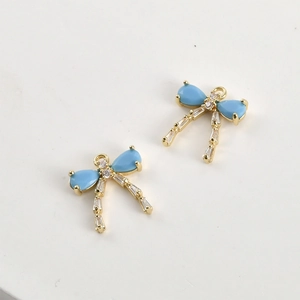 Macro view of blue teardrop zircon bow pendants with 14k gold plating for DIY jewelry