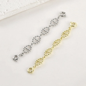 Macro detail of 14k gold-filled pig-nose extension chains with double-headed spring ring clasps
