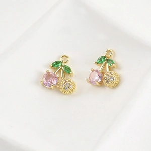 Detail of 14k gold plated cherry pendant with pink zircon and green marquise leaves