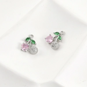 Detailed view of cherry pendant with pink and green zircon in 14k gold plating