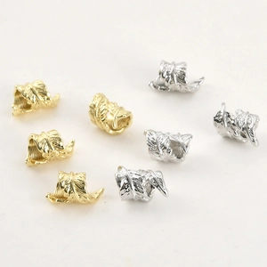 Detailed view of 14k gold and silver feather-shaped beads for DIY jewelry making